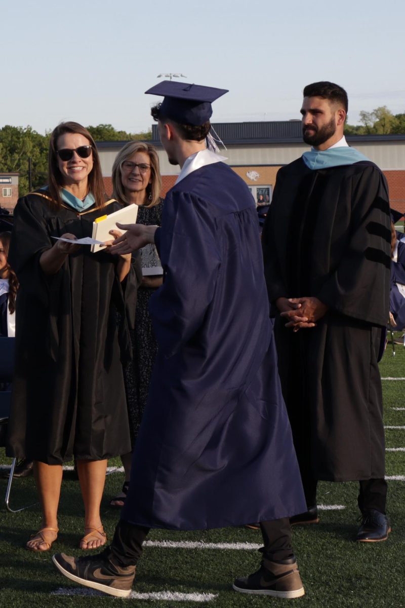 Dynamic duo, librarian Ashley Agre and Vice Principal Dr. Heath Wilson, hand students their diplomas.