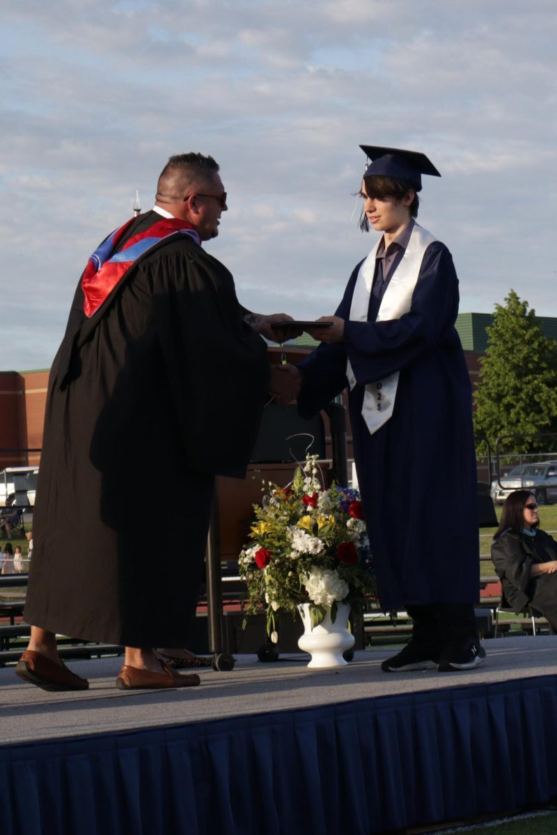 Senior Colin Devery receives his diploma from Superintendent Cory Gibson.