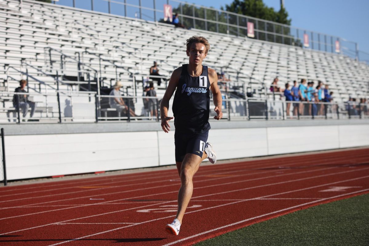 Rounding the curve during the 1600 meter race, senior Carter Cline focuses on pacing himself.