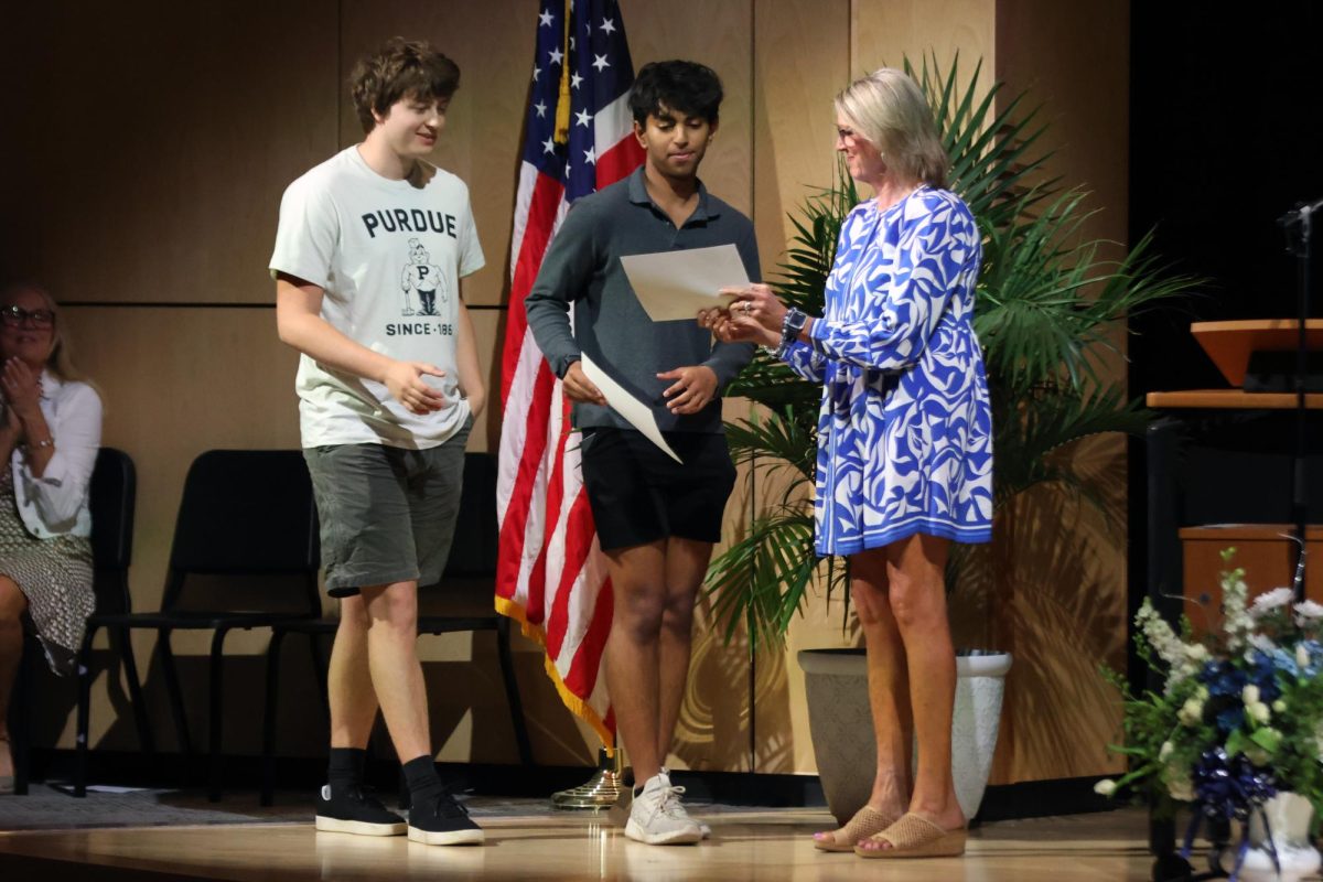 Walking onto the stage, seniors Shubh Patel and Carter Tollman receive an award.