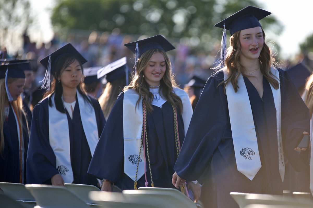 Filing in, seniors Evey Maniquis, Emma Mahoney, and Allyson Makalous find their seats for the ceremony.