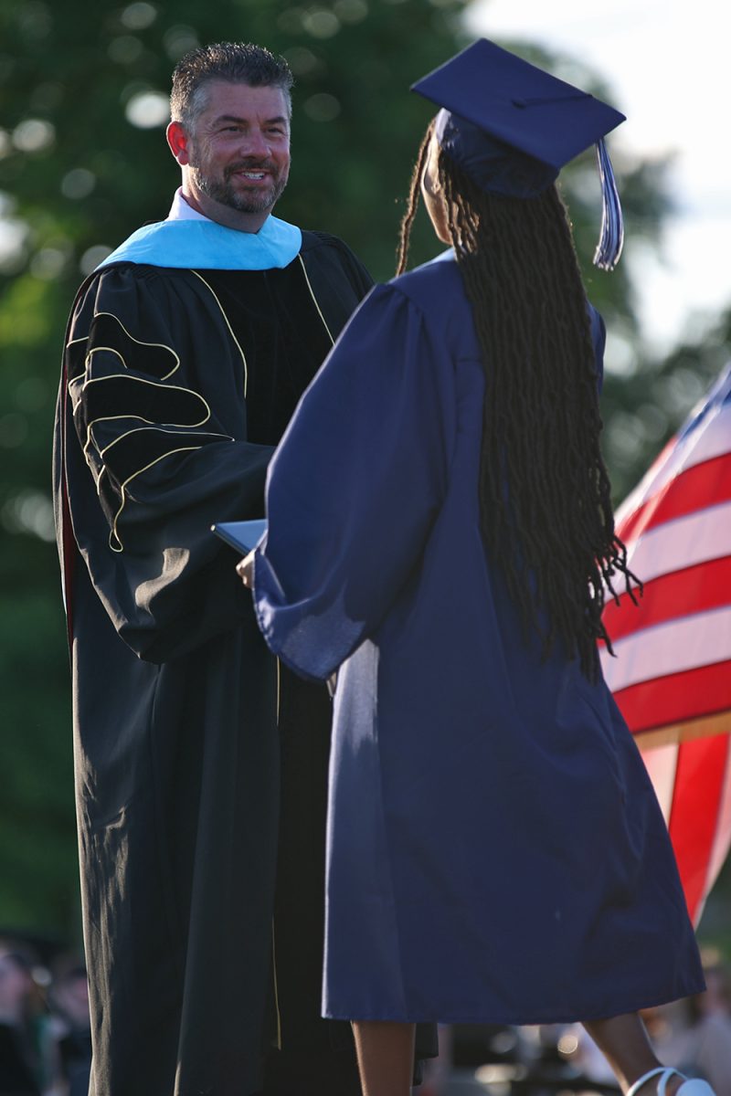 With a smile, superintendent Cory Gibson shakes the hand of a graduate after she received her diploma.