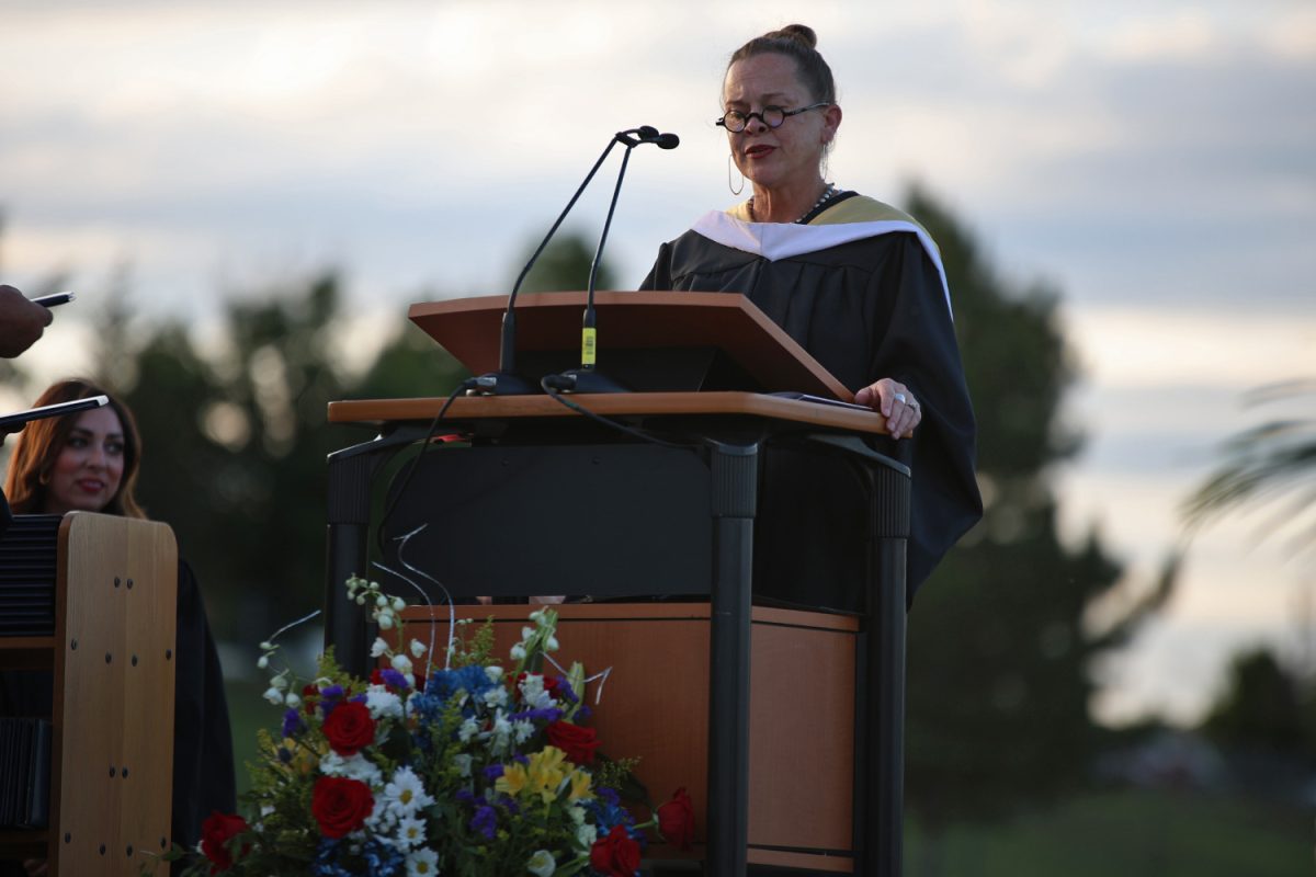 English teacher Kristen Huang reads students names while they walk across the stage.