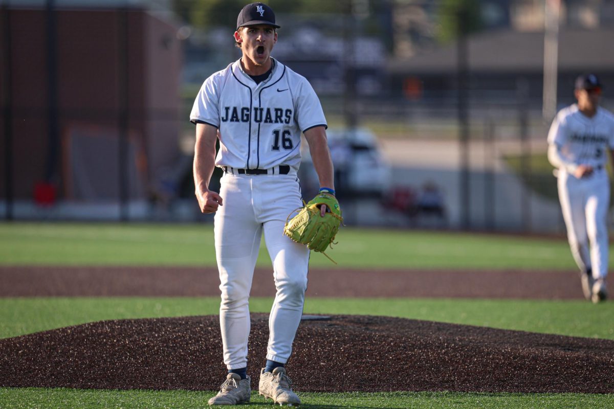 After striking out a batter, junior Beau Peterson flexes while walking off the mound.