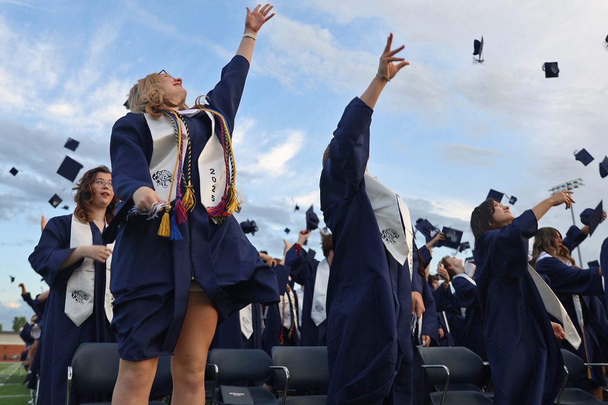 With a glance to the sky, senior Marissa Akehurst tosses her cap into the air.