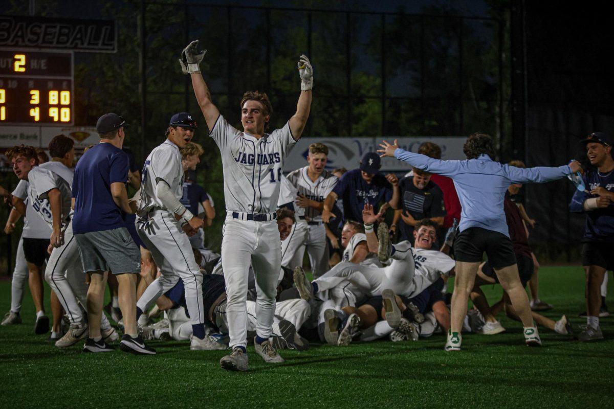 with his hands up, junior Beau Peterson celebrates after the win.
