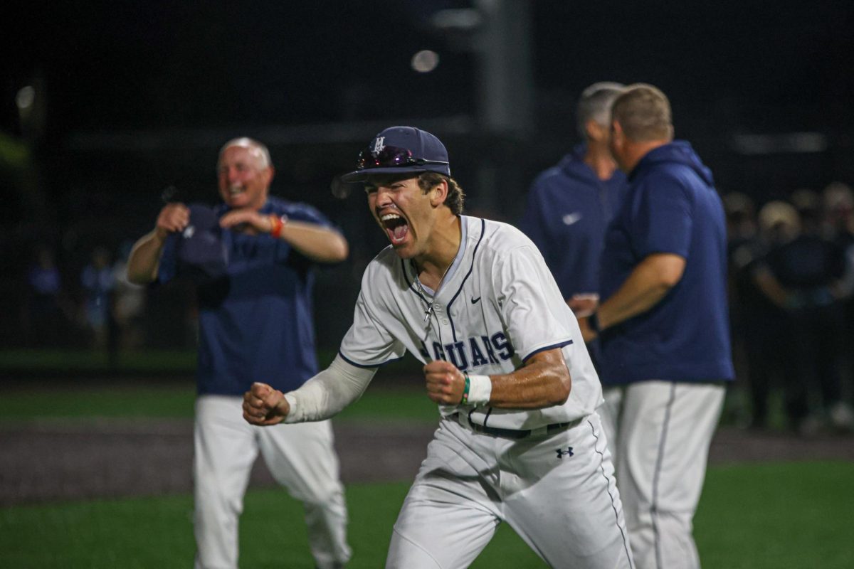 Flexing, senior Isaac Sauder yells after dumping water on the coaches.