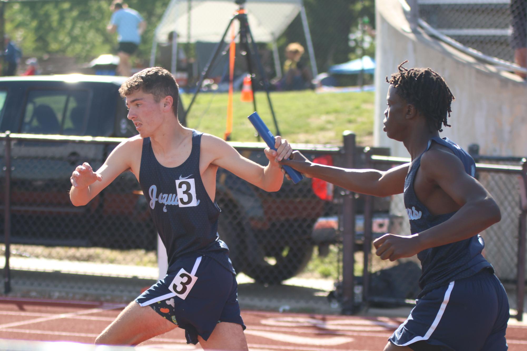 Junior Cayden Rotich passes the baton to junior Gus Malone in the boys 4x800 relay on May 15. 