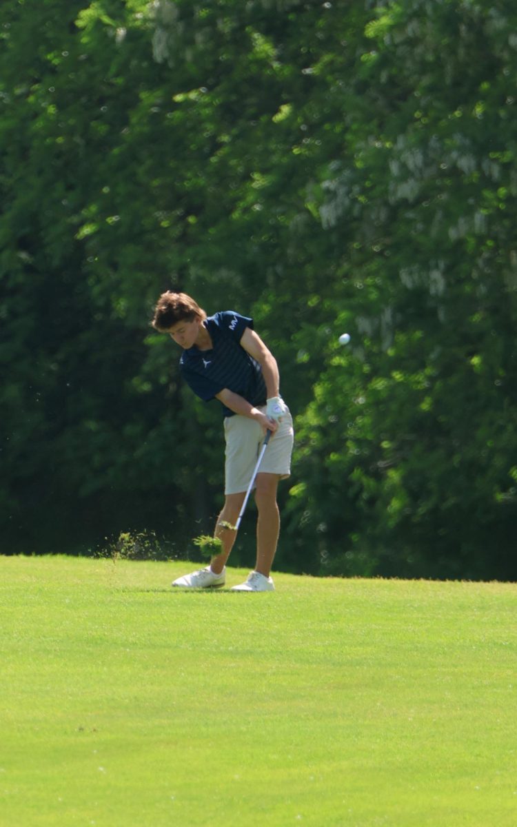 Mid swing, junior Bradyen Repp hits the ball.