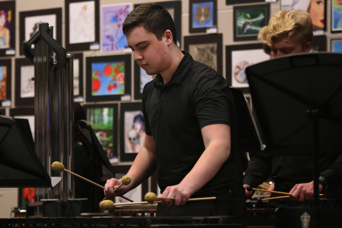 Sophomore CJ Hereth plays with the other percussionists before the concert. 