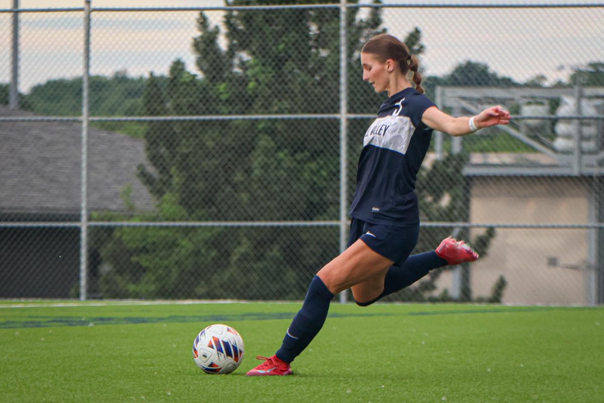 With her leg back, senior Kate Martin kicks the ball down the field. 