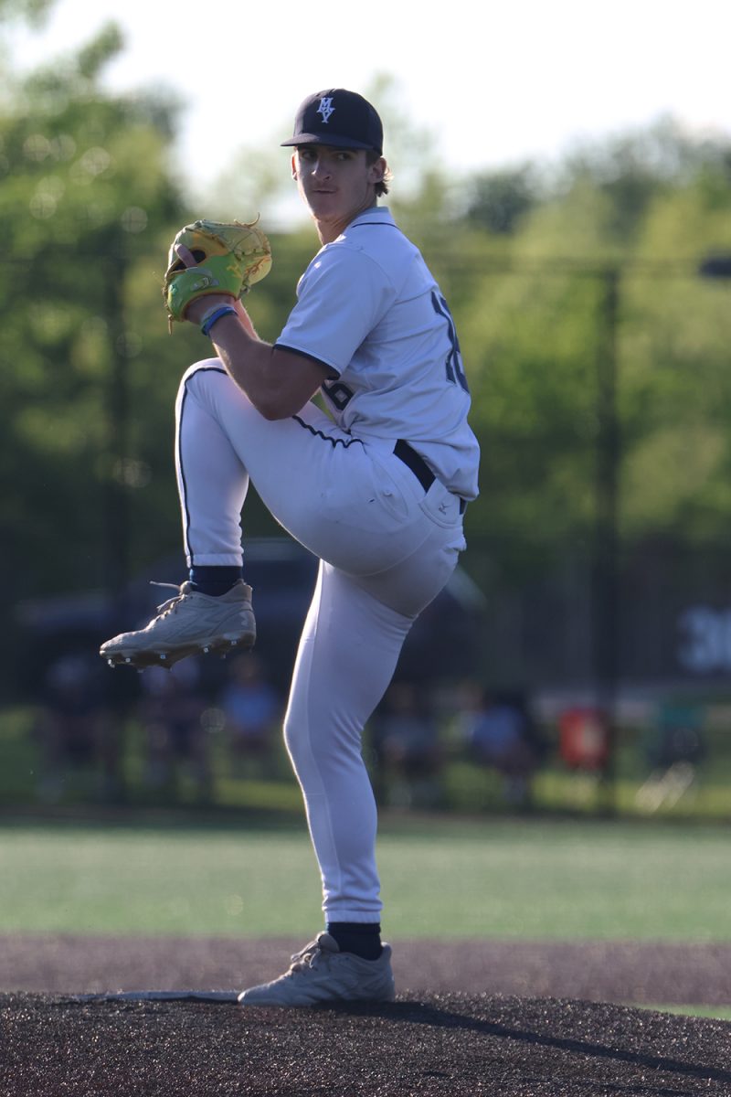 Leg up, junior Beau Peterson winds up and pitches the ball in the second game of regionals.