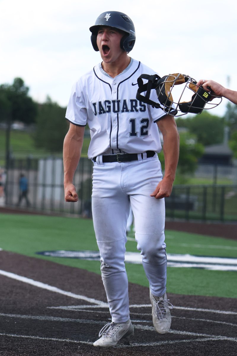 Yelling, senior Hudson Powers celebrates scoring the first run in the first game of regionals. 