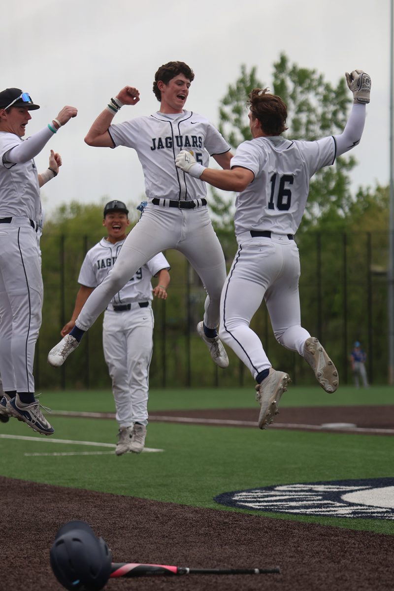 After hitting a homerun to right field, junior Beau Peterson and Connor Bohon jump in the air to celebrate. 
