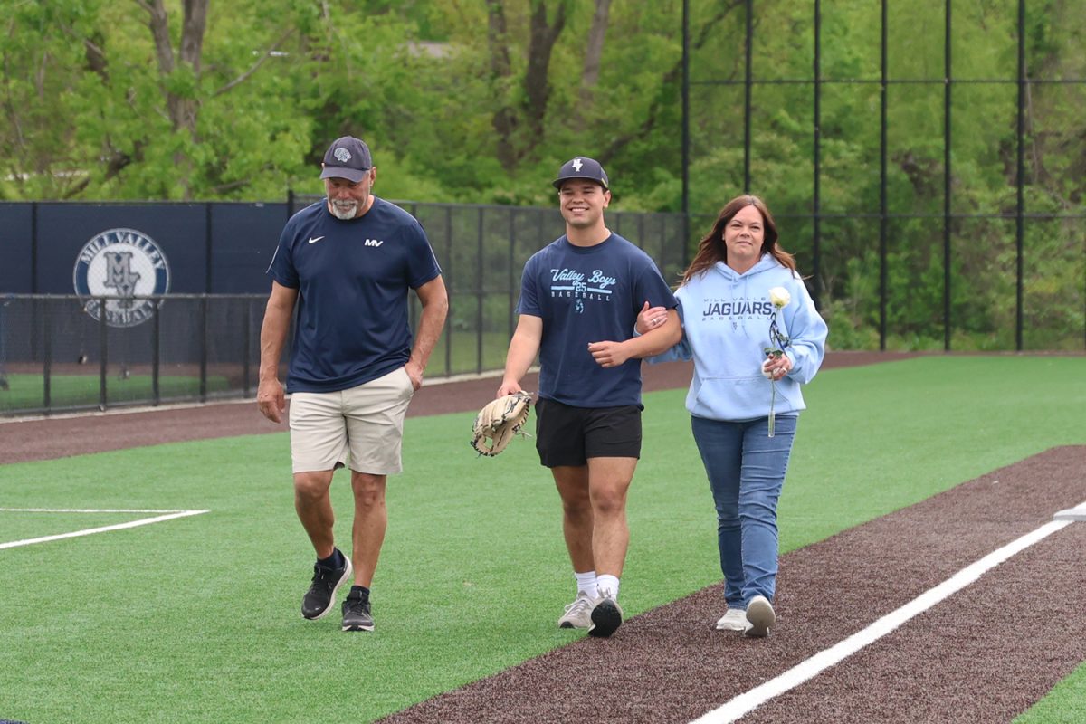 With a smile on his face, senior Zach Zaldivar walks with his parents as he is recognized on senior night. 