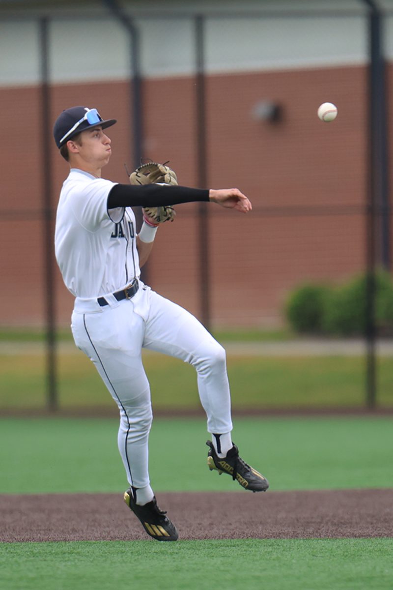 Throwing the ball, junior Blake Jay gets the out at first base.