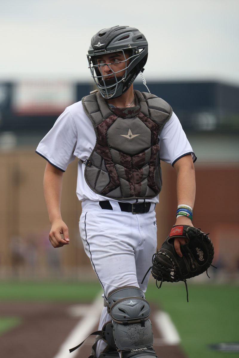 Looking at the dugout, senior Owen Gietzen receives the pitch call from Coach Jeff Strickland.