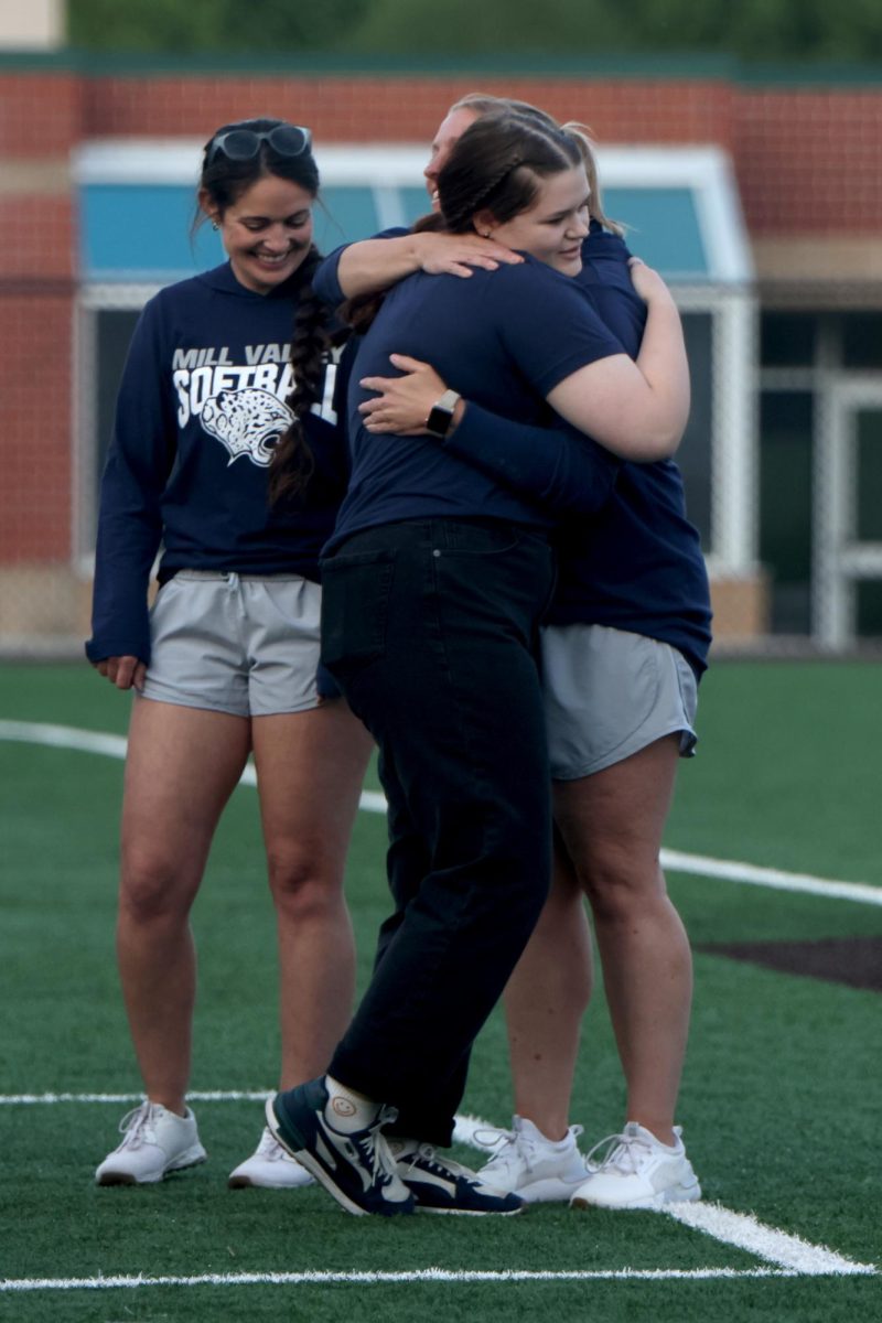 Hugging head coach Jessica DeWild, manager senior Hannah Lewis gets announced. 
