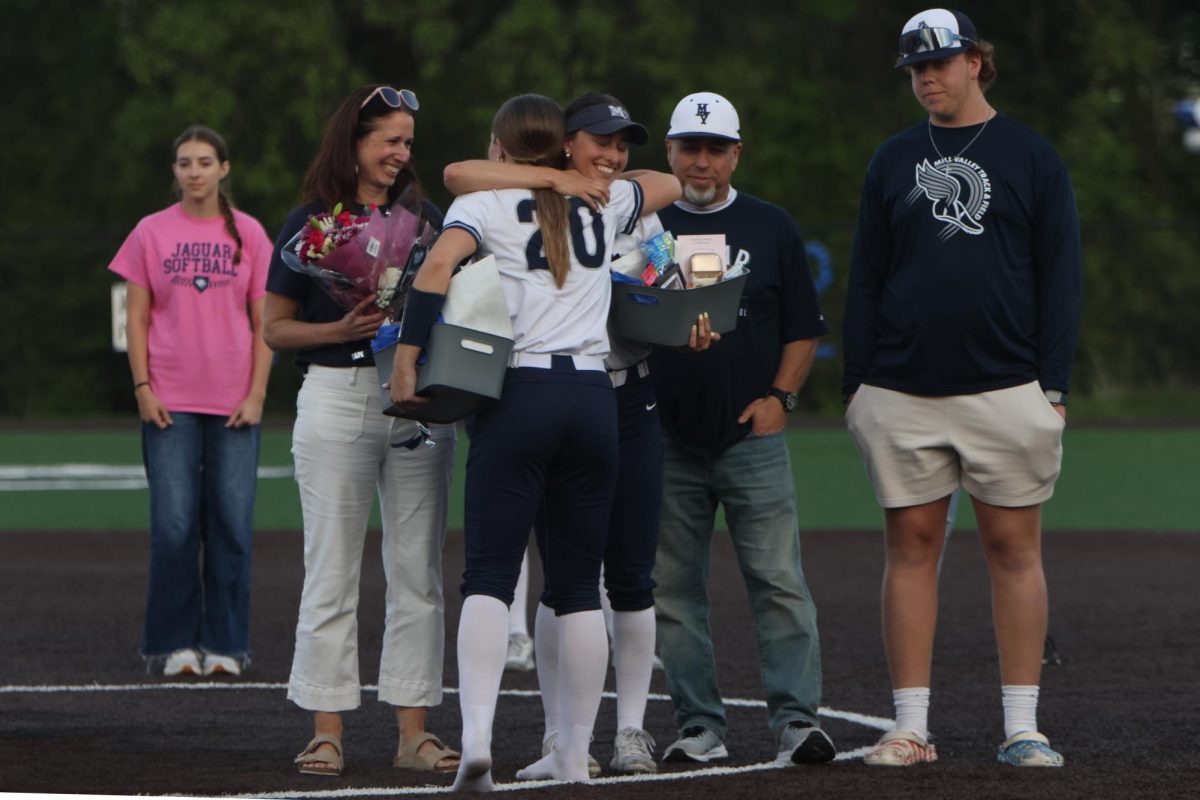 Holding her senior gift, senior Madi Lehr hugs junior Callie Caldwell.
