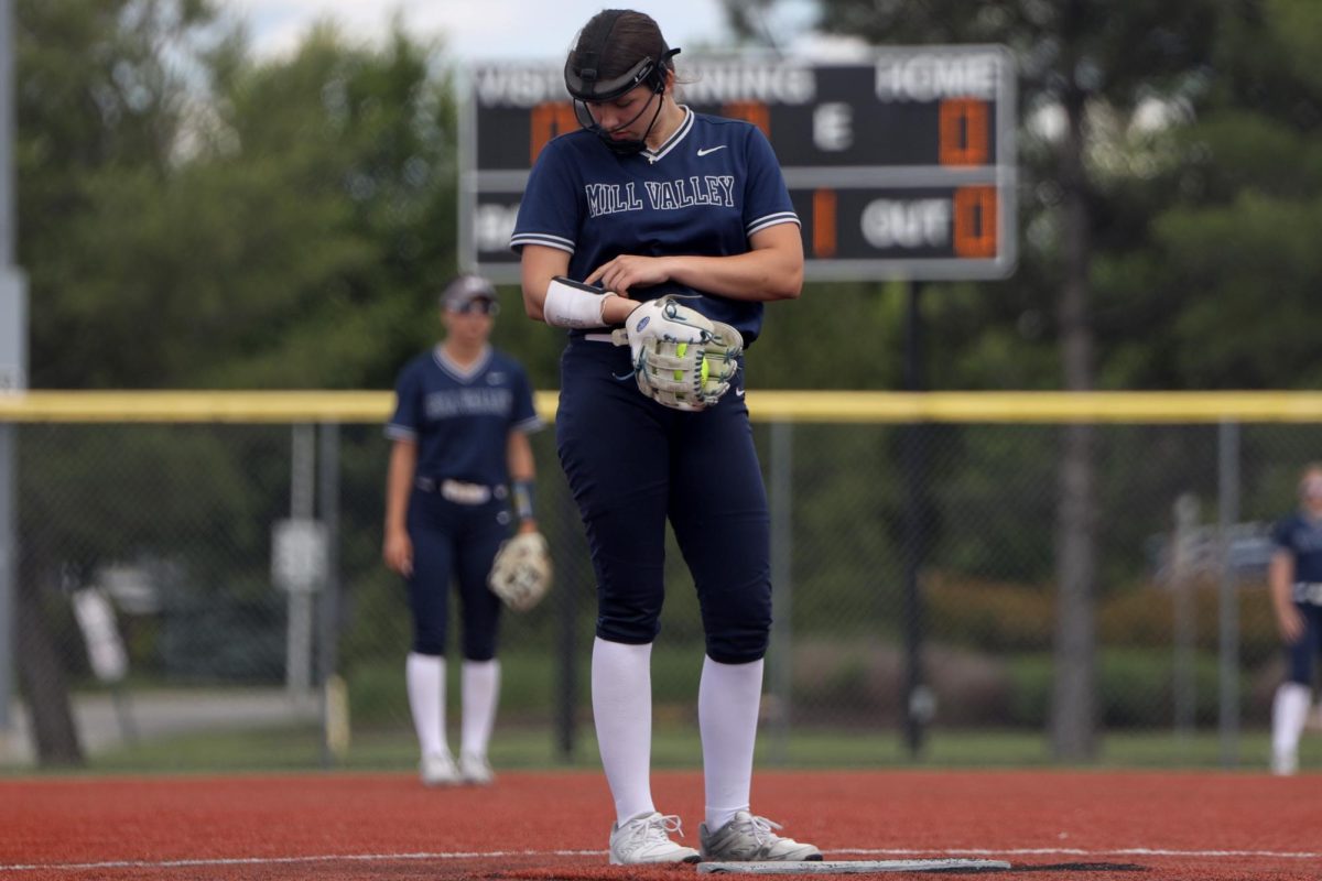 Reading her wristband, sophomore Emma Hadley finds the pitch called in the first round of the regional tournament Thursday, May 22.. 