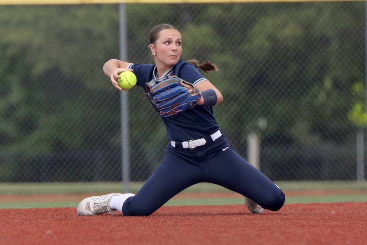 Moving across the field after making a diving play, freshman Logan Waters throws the ball. in the first round of the regional tournament Thursday, May 22.