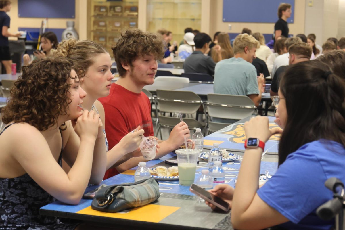 Enjoying the senior breakfast, seniors Madelyn Shimmel, Laiyah Kirkpatrick and Ayden Brown sit together and talk.