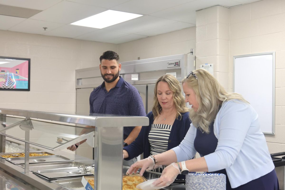 Preparing for the students, counselors Erin Hayes and Patricia Chandler and Vice Principal Heath Wilson help with serving breakfast.
