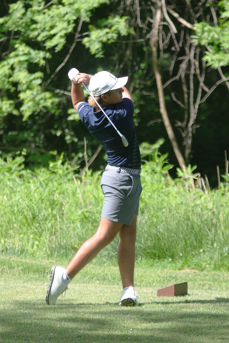 Completing his swing, senior Jackson Sprecker watches to see where his ball lands.