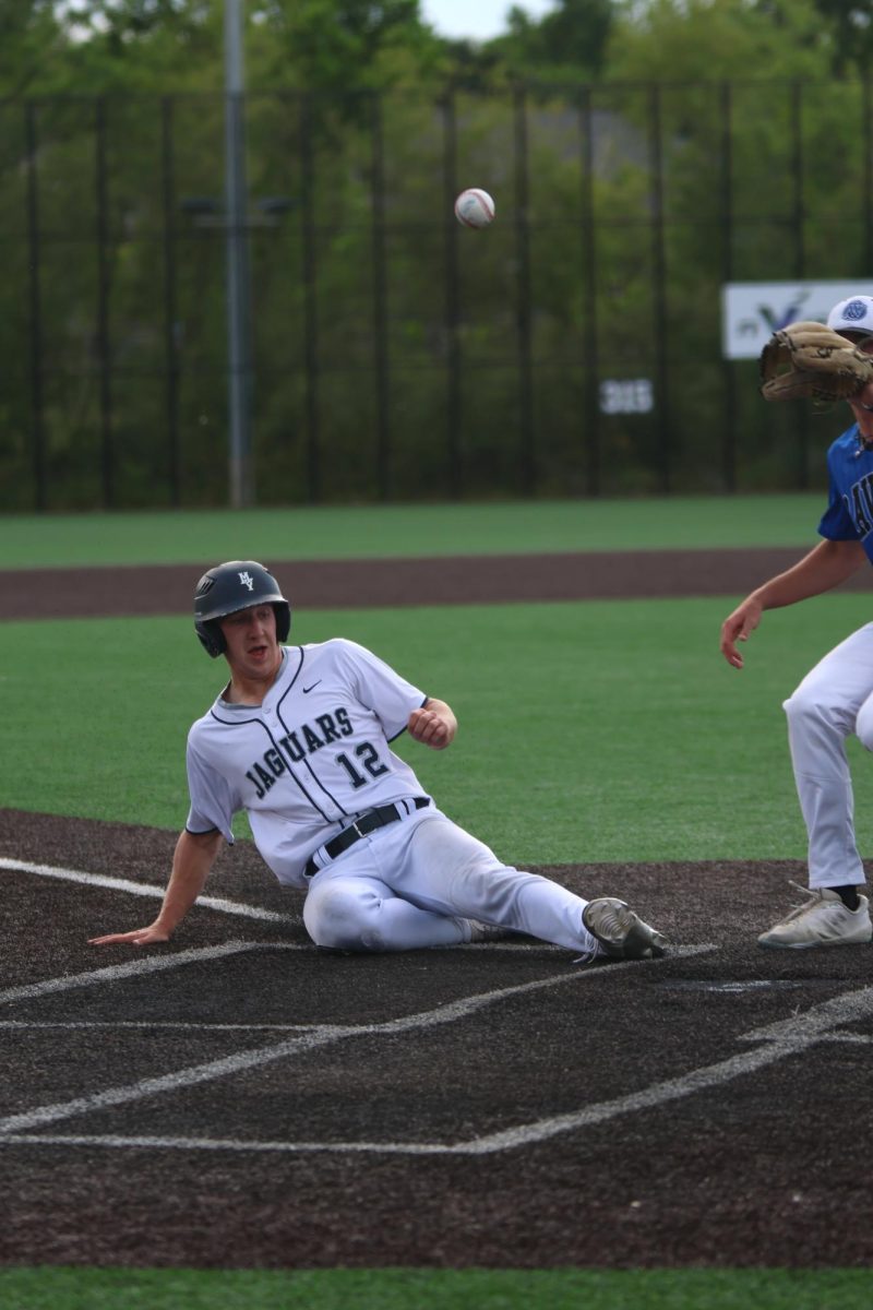 Sliding, senior Hudson Powers scores for the team at regionals. 