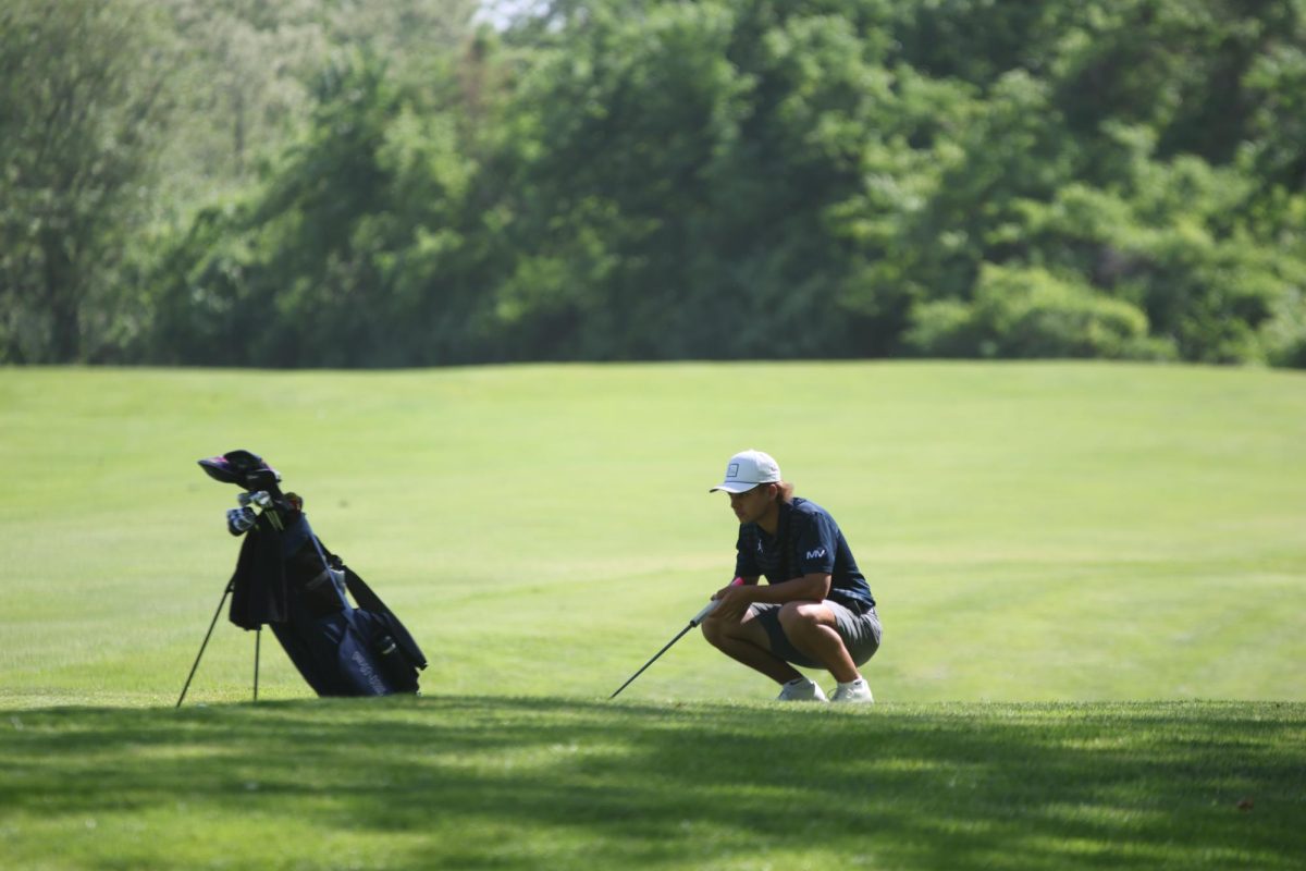 Carefully lining up his putt, senior Jackson Sprecker gets ready to finish the hole.  


