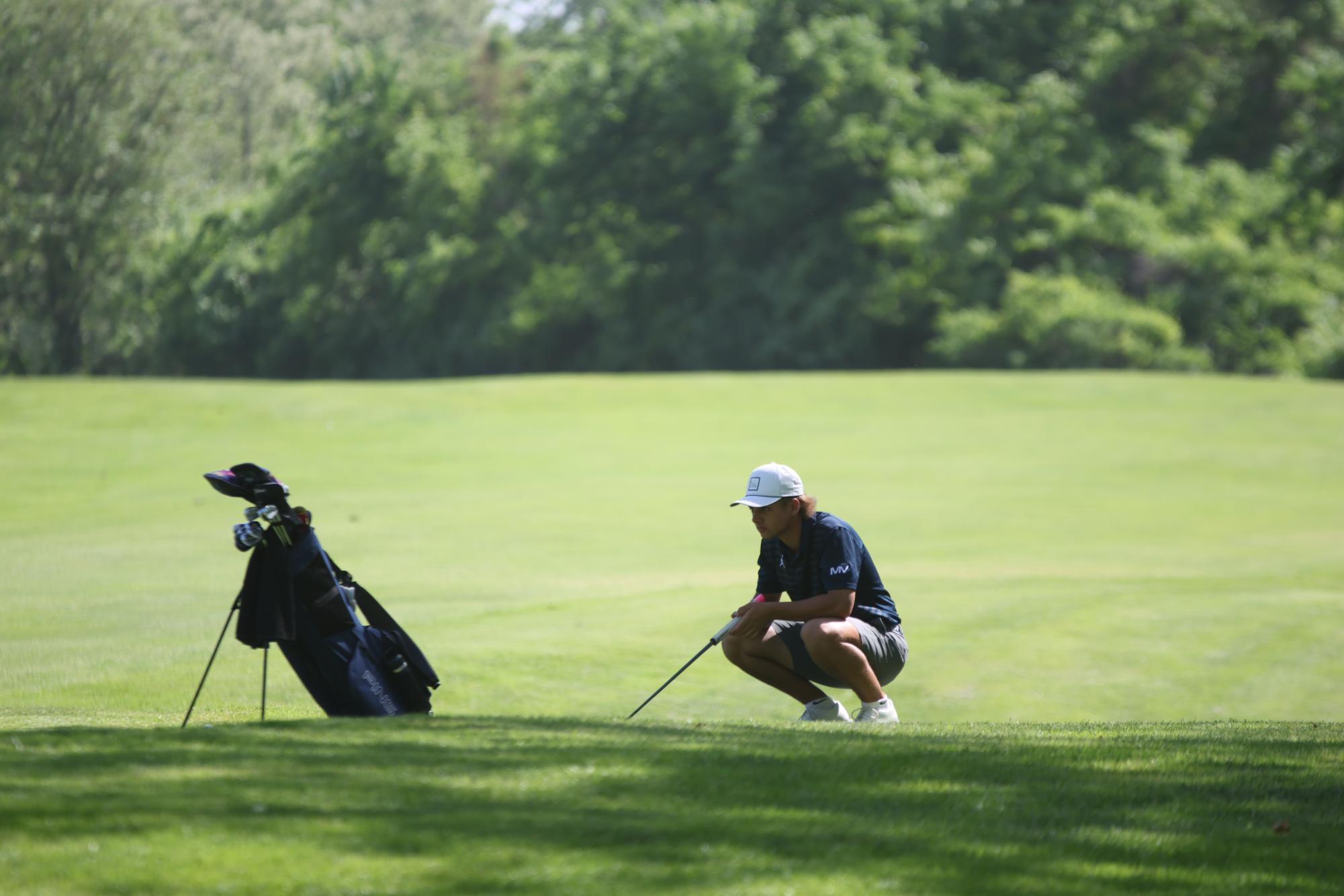 Carefully lining up his putt, senior Jackson Sprecker gets ready to finish the hole.  

