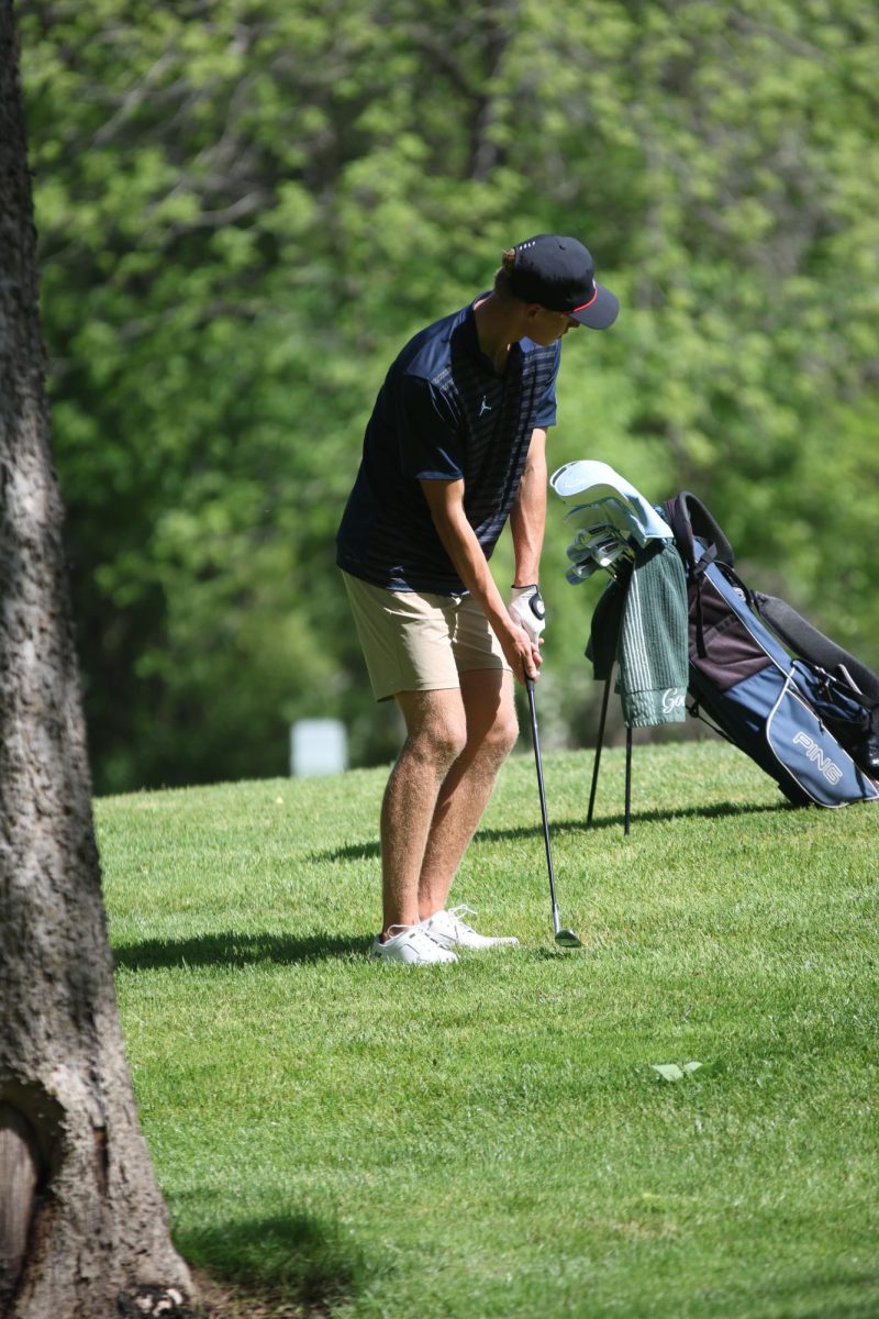Dialing in the distance, hoping for a good lie on this approach shot, sophomore Eli Platz practices swings. 