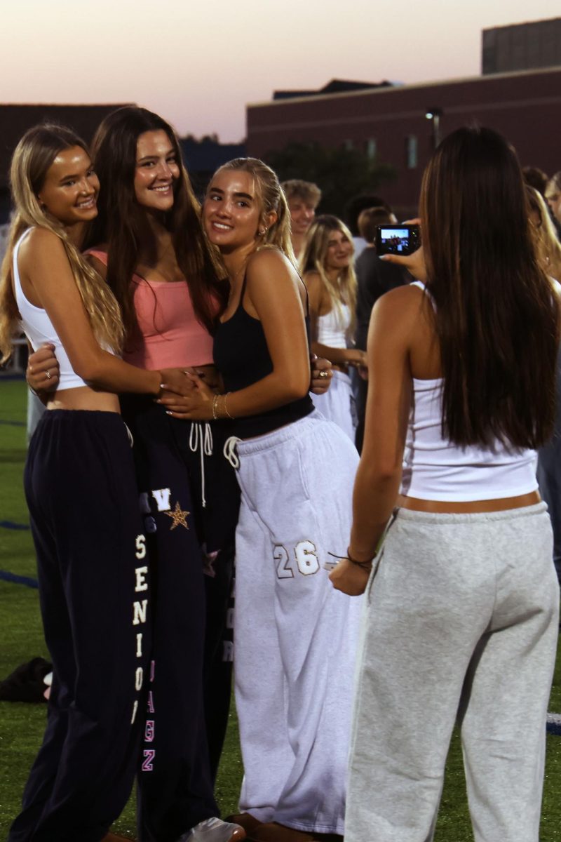 Hugging, seniors Miley Strathman, Paige Roth and Claire Cooper pose for a digital camera picture. 