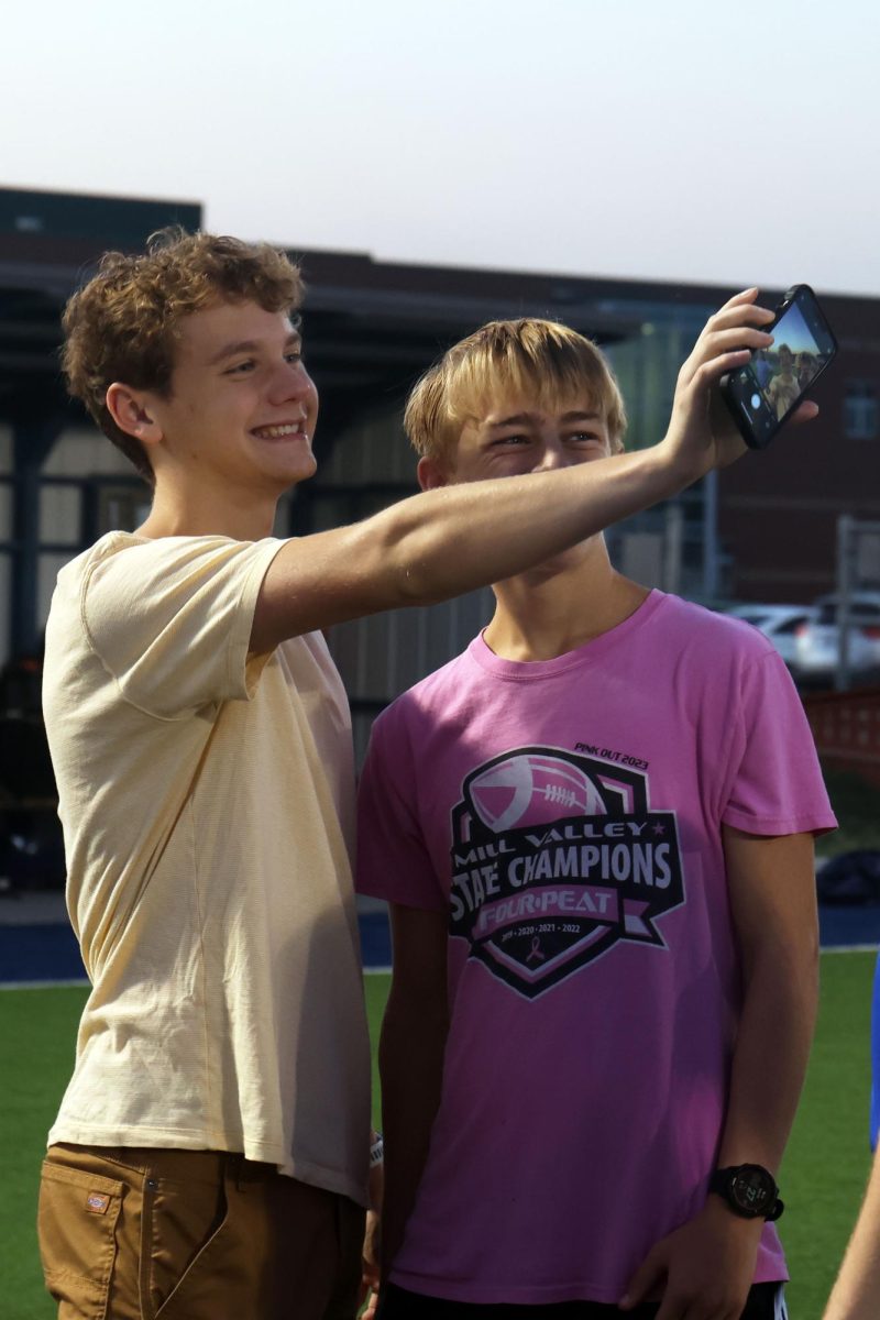Senior Max Reynolds hold his phone out to take a selfie with his friend senior Dillon Schmidtmann.