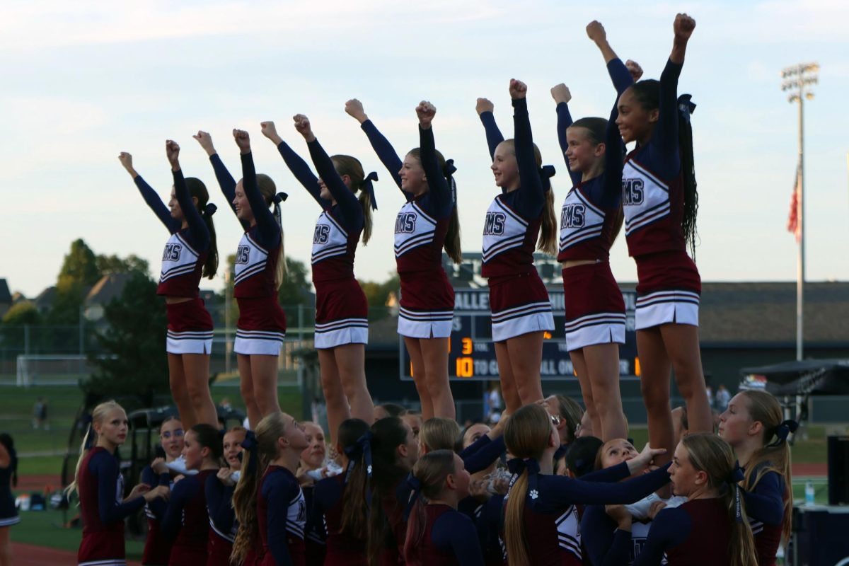 Arms up, the Monticello Trails Middle School cheer team are raised into the air. 