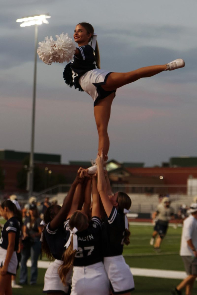 Foot raised, sophomore Isabelle Rangel smiles towards to crowd.
