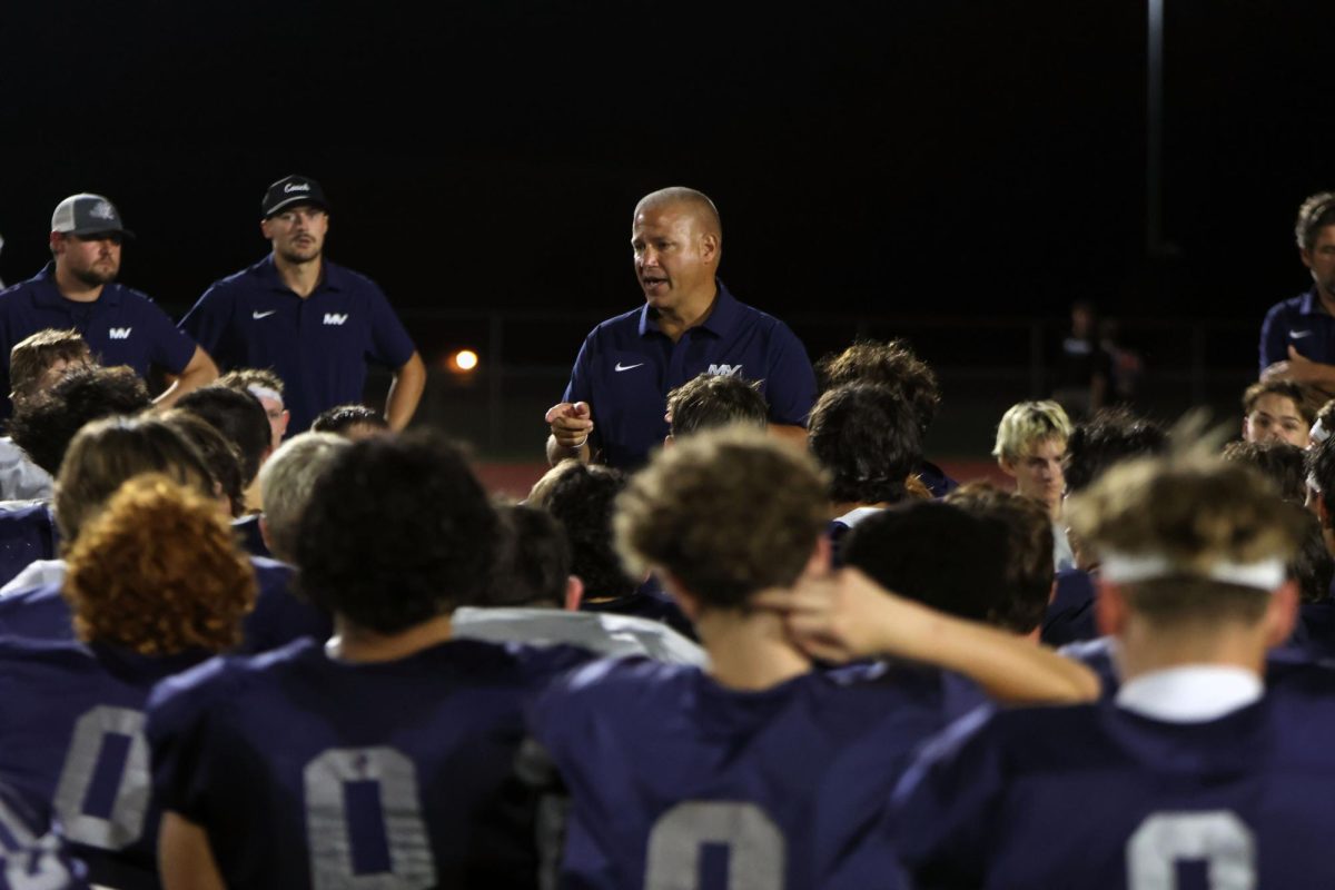 Coach Joel Applebee gives an uplifting post game pep talk to the football team. 