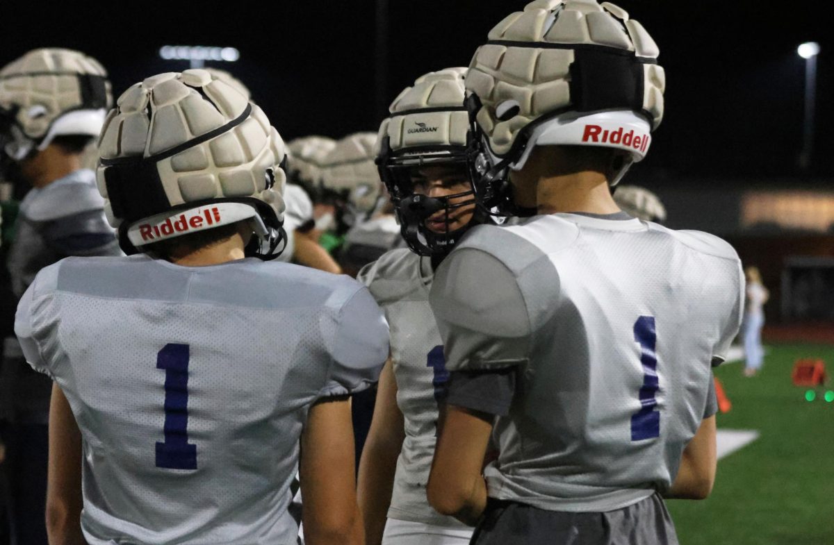 Members of the silver football team go over the teams play on the sidelines during the high school scrimmage, Thursday Aug. 28. 