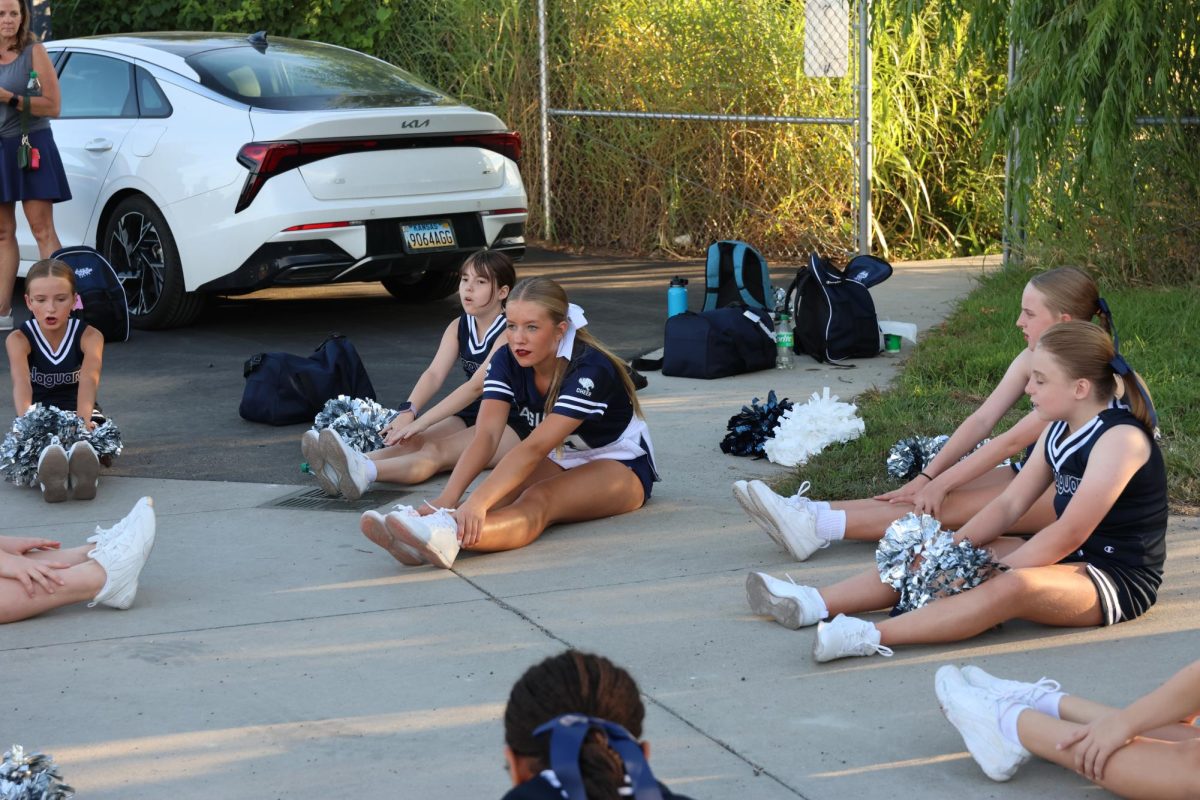 MV cheerleader leads the Junior Jag cheerleaders in their pre-performance warmups and stretches, Thursday Aug. 28.