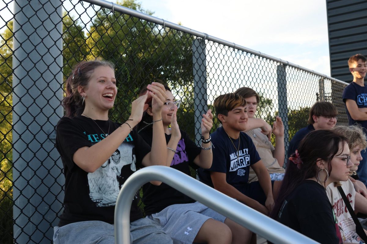 Sophomores Bella Davidson, Millie Weatherford, Gabriel Morales, Xander Merriman, Greyson Knight, William Ottesen, Eleanor Mitchell, and Zoey Zagorsky cheer on the middle school football scrimmage from the crowd. 