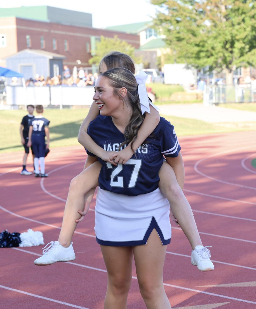 Junior Kenadi Harris gives a Junior Jag cheerleader a piggyback ride during a break between their cheer practice. 