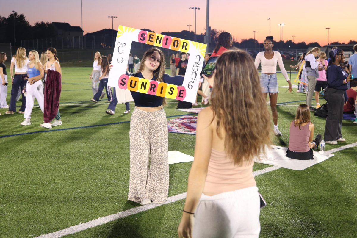 With a homemade sign, senior Bianca Pepe holds the memory of senior sunrise.