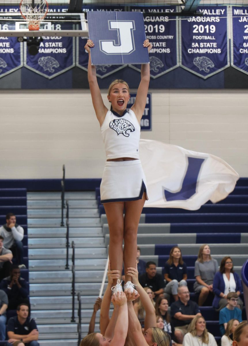 Holding up a "J" sign, senior Sydney Epperson urges the new students to chant along.