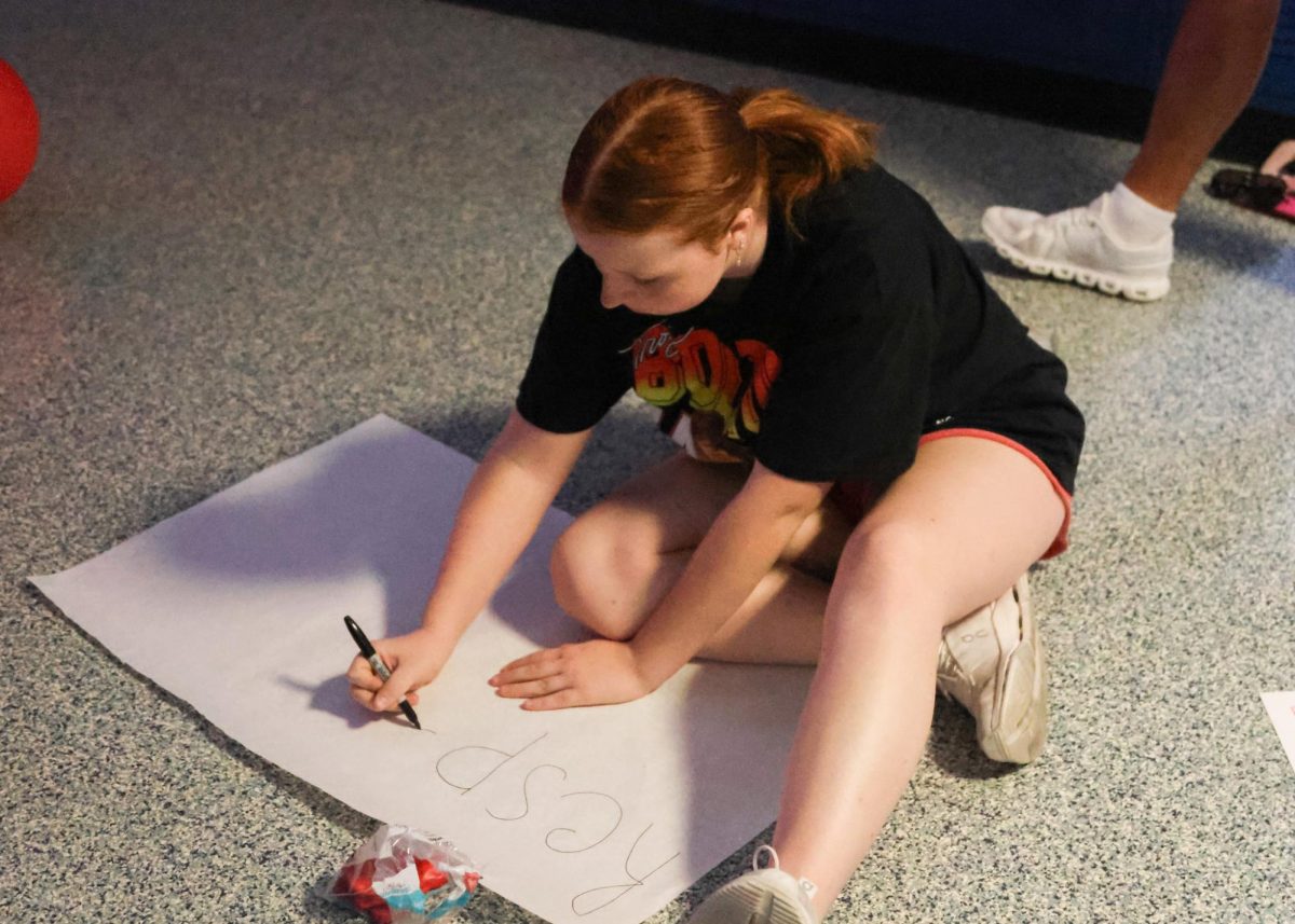 Focused, junior Hadley Doyle makes a poster to hang up in the junior hall. 