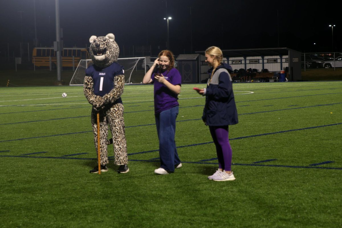 Relay for Life chair and junior Hadley Doyle gets ready to announce the winner of the Chuck-A-Duck competition at the RFL Purple Out soccer game, Tuesday Sept. 23.