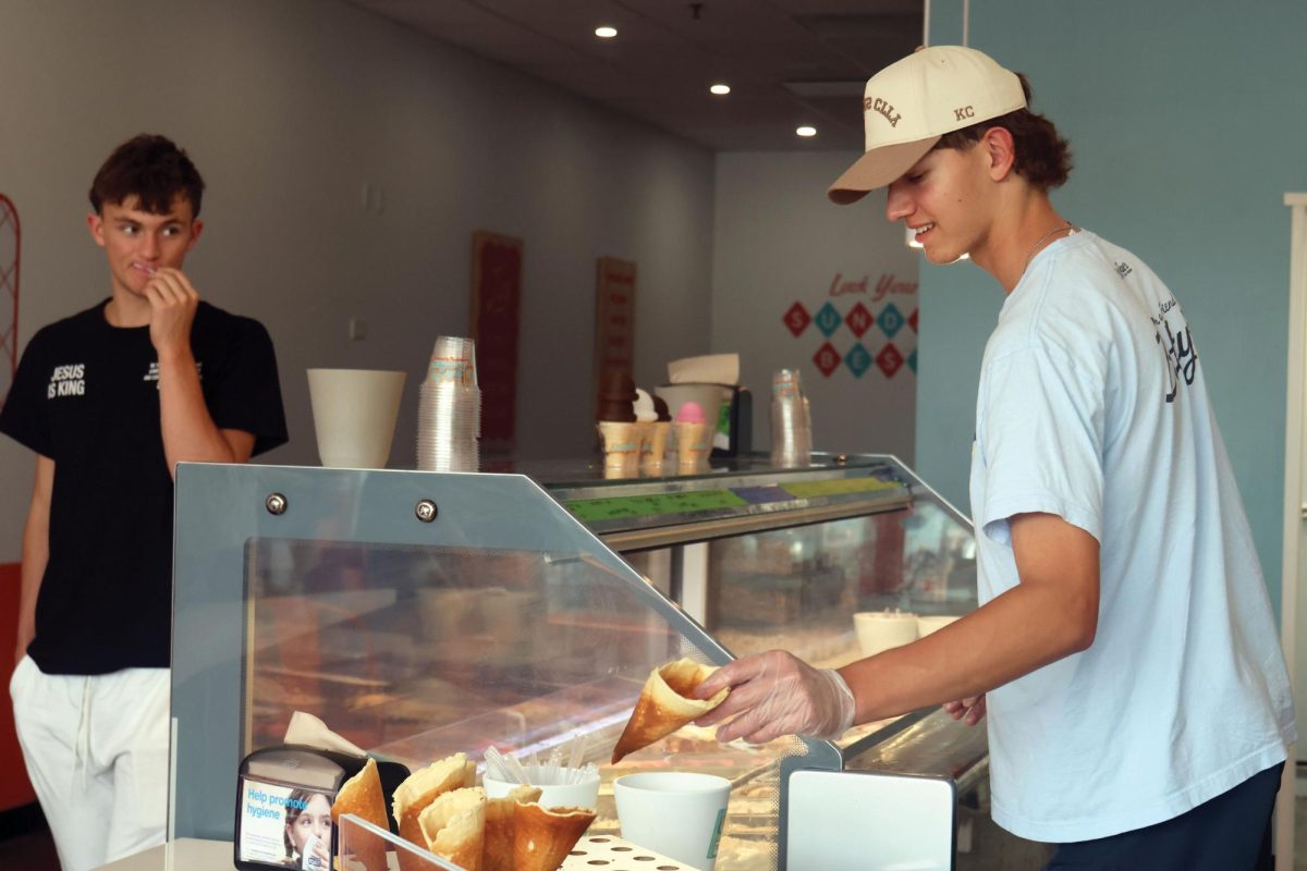 During his shift at Betty Rae’s, Junior Ethan Broxterman reaches out to get a waffle cone for customer senior Reece Riedel on Friday Sept. 12.