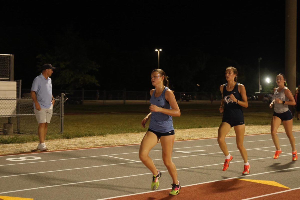 Running ahead of her opponents, junior Clara Hanks sets a new personal record at the Olathe Twilight race.