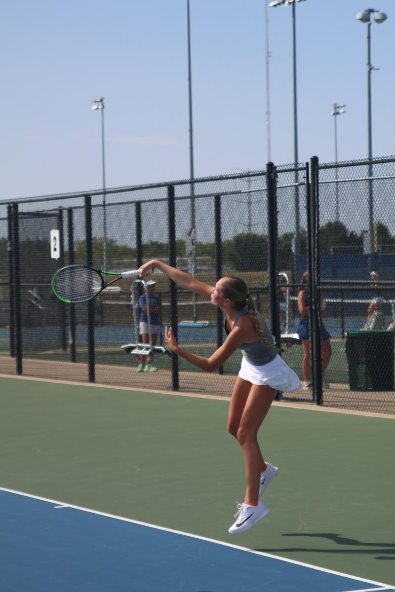 Senior Bryn Foltz finishes her serve, starting a rally