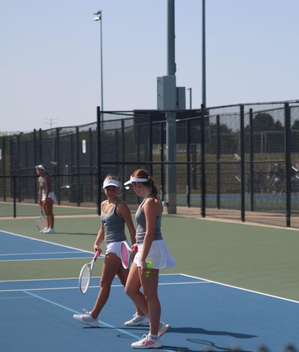 Junior Ella Ericson and sophomore Zoe Wendel chat while walking off the court. 
