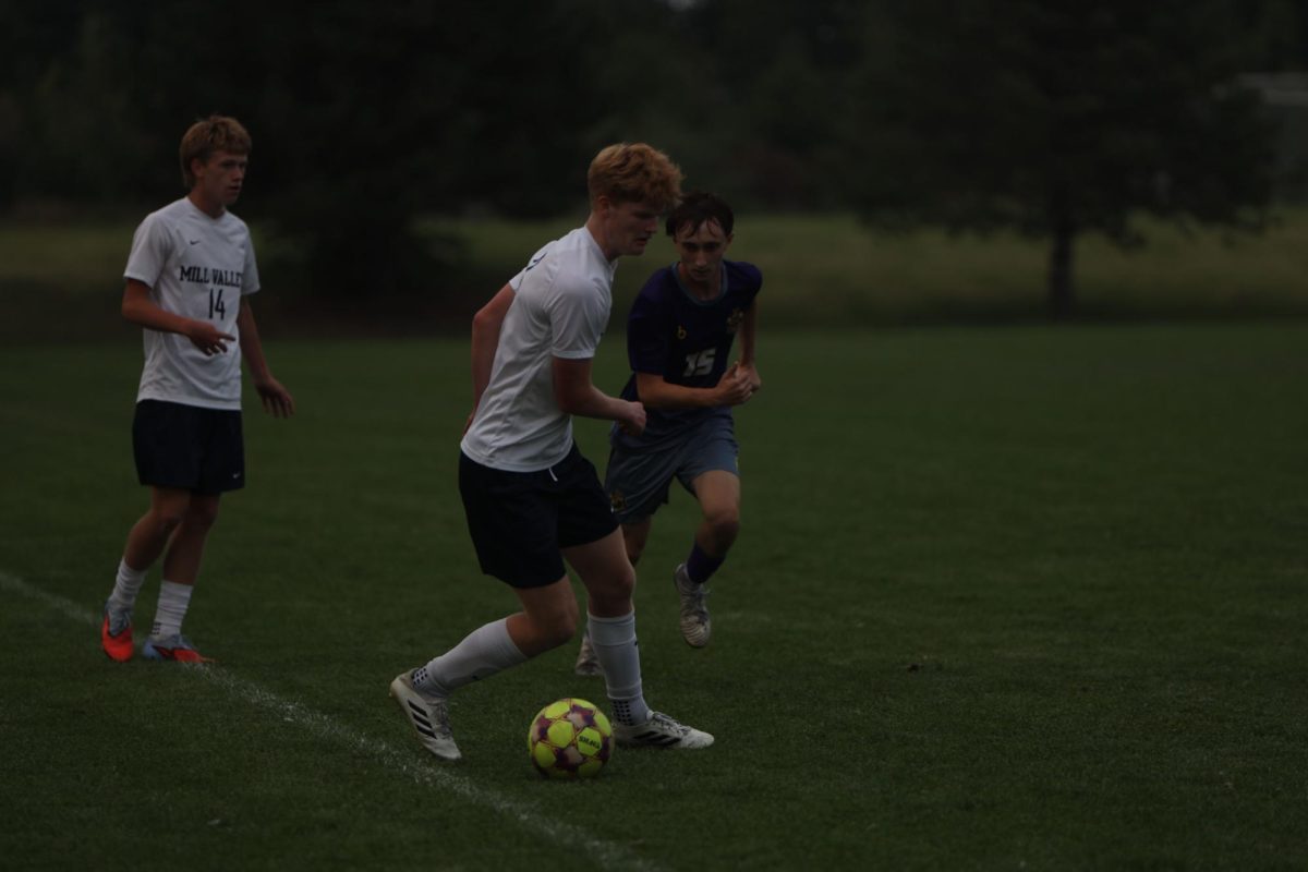 Senior Caleb Hayes keeps the ball away from the opposing team during the game on Sept. 4. 